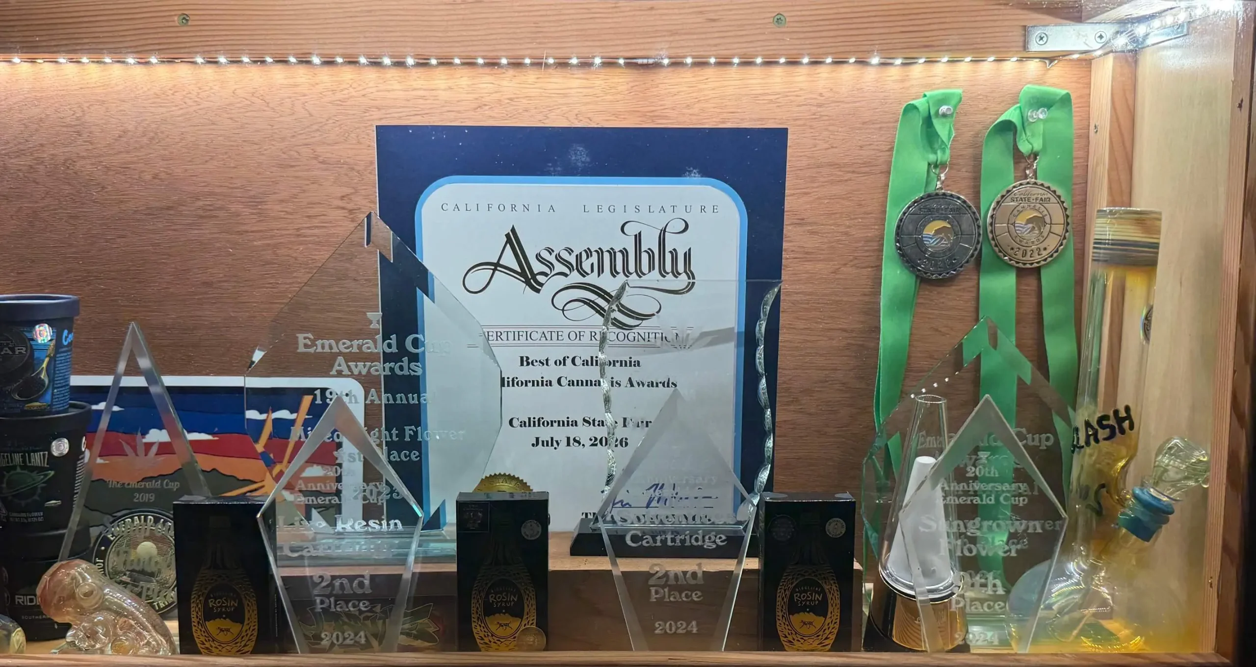 Ridgeline Farms cannabis industry awards, competition medals, and California State Assembly recognition displayed in a trophy case